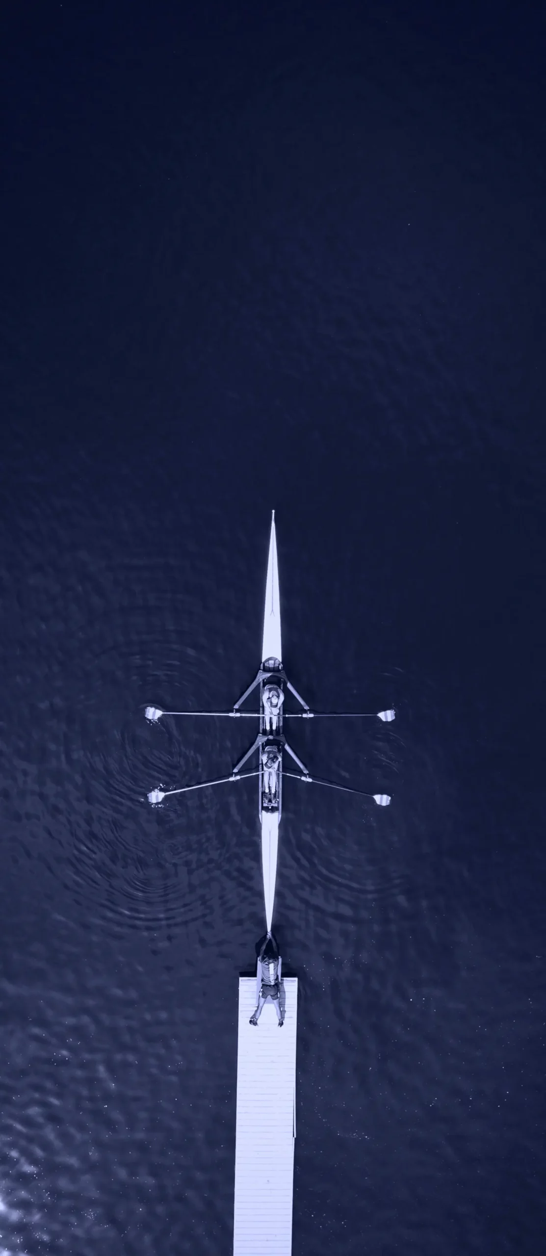 Vue aérienne d'une équipe d'aviron en navigation symbolisant la transformation et la croissance des PME chez B & Capital