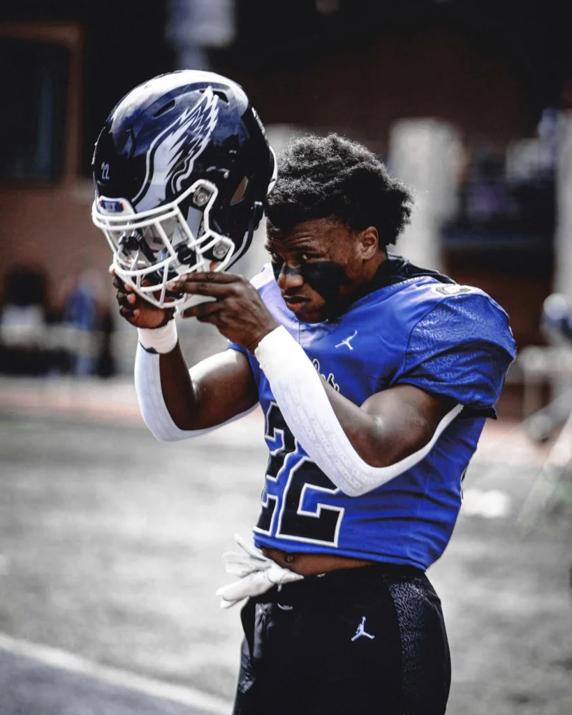 Joueur de football ajustant son casque, évoquant la préparation rigoureuse du partenariat Roland Berger.